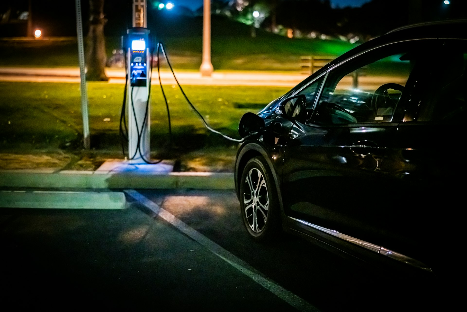 coche eléctrico negro cargando de noche