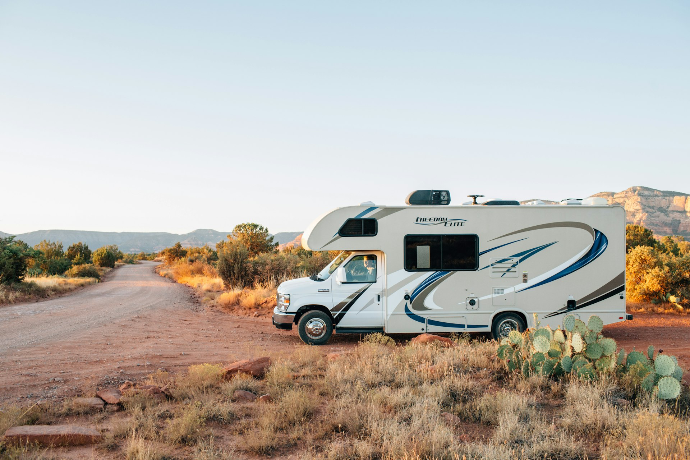 white and brown rv on brown grass field during daytime