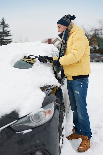 hombre quitando la nieve de encima de su coche hombre quitando la nieve de encima de su coche