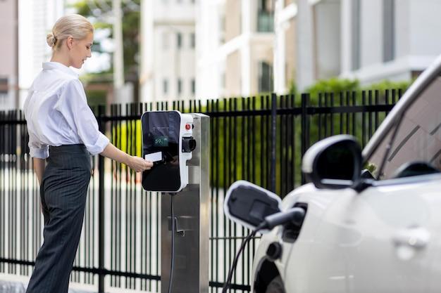 mujer cargando su coche electrico