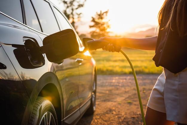 chica poniendo a cargar su coche electrico